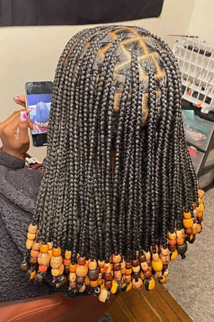 Shoulder-Length Black Braids with Orange Beads