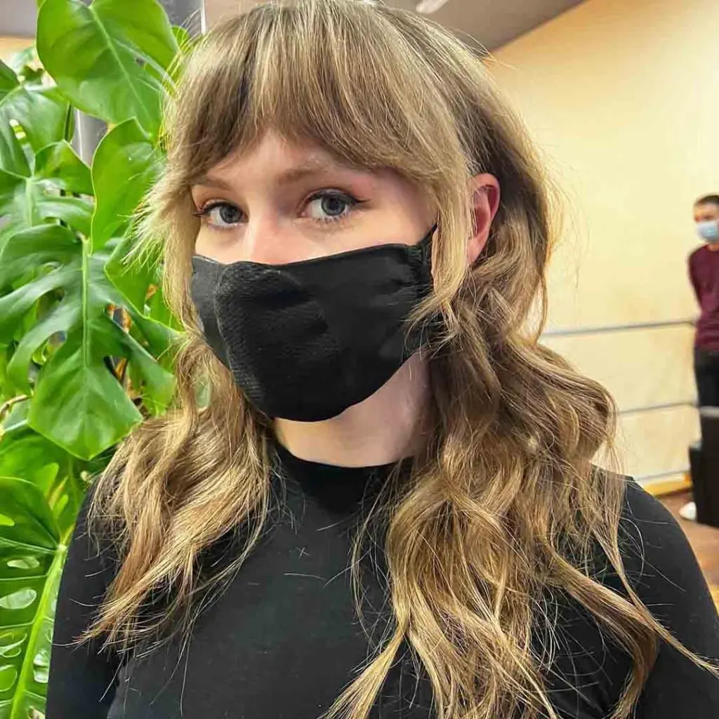 Razor Wolf Cut on Bronde Wavy Hair With Curtain Bangs